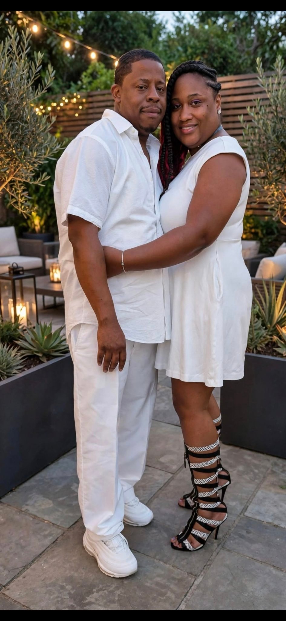 Ron and Tee in white outfits under string lights